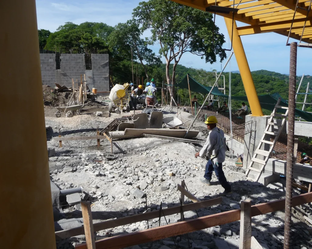 Etapa de construcción del deck con estructura metálica amarilla y trabajadores en obra.