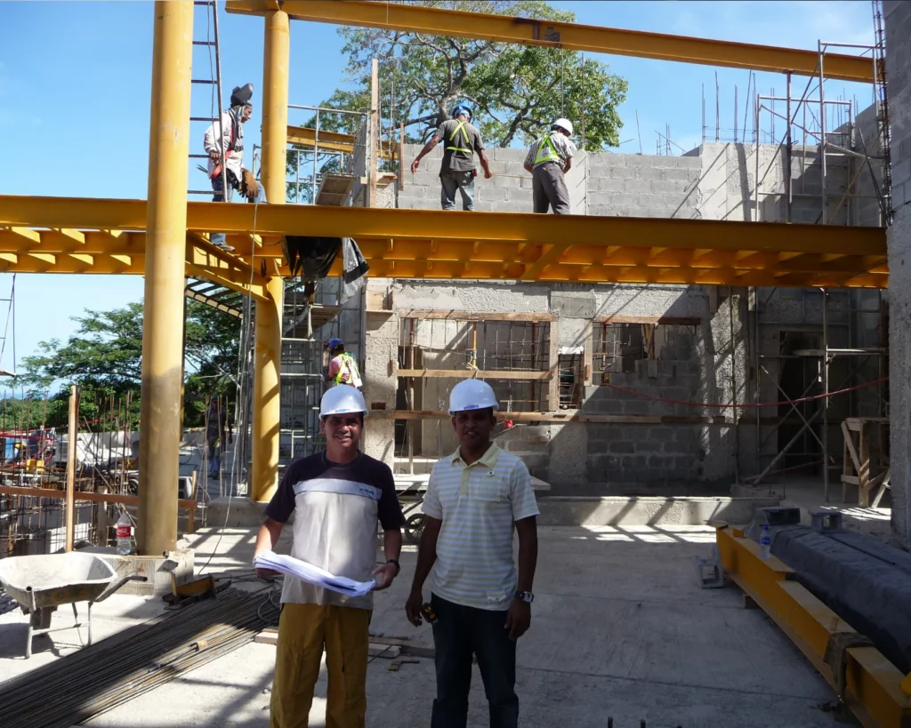 Supervisión de obra en terraza con estructura metálica y muros de bloque en proceso de construcción.