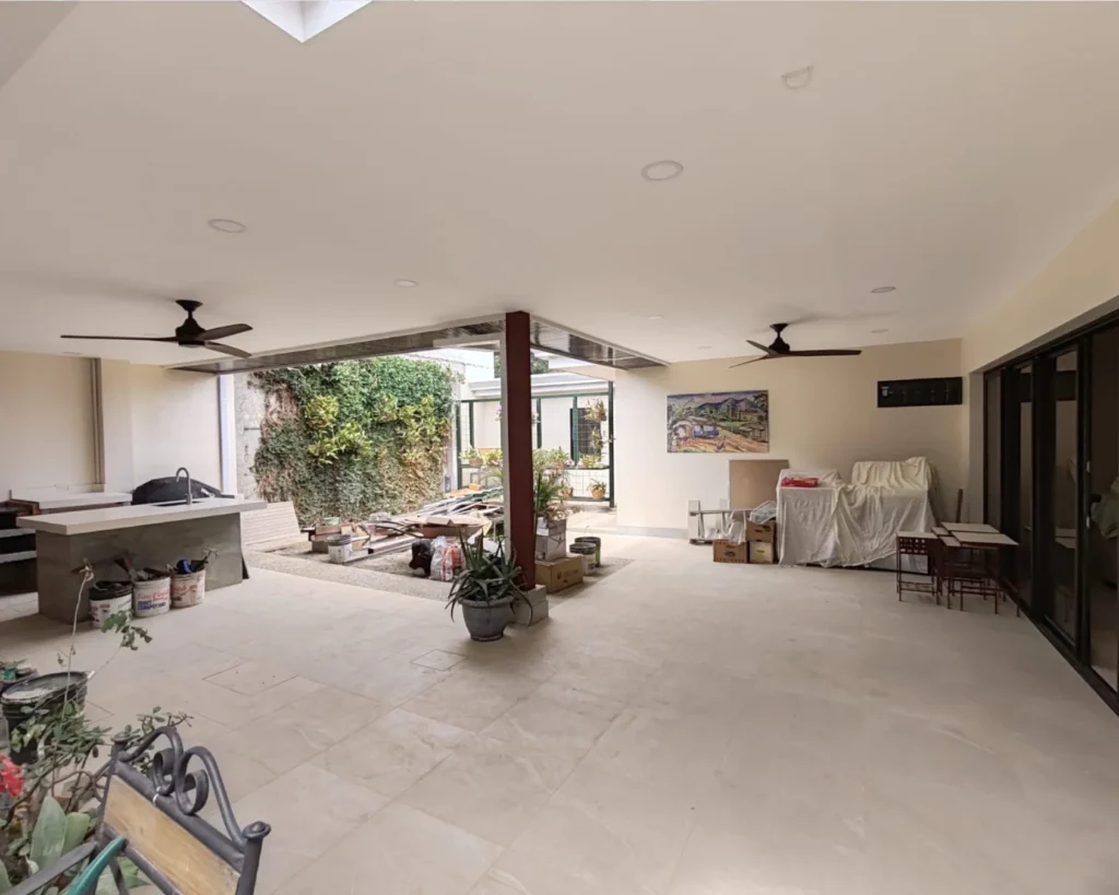 Vista general del área de terraza techada en remodelación, con estructura completa y ventiladores de techo instalados